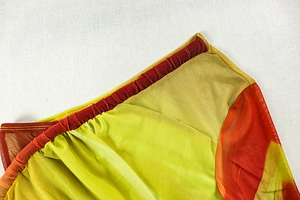 Detail of color-block dress showing mesh pleating and ruching craftsmanship on seam