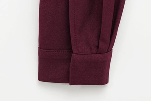 Détail du poignet d'un blouson aviateur rouge foncé avec tissu sergé et coutures