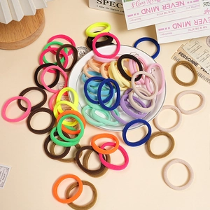 Detail of colorful high-elastic hair ties in a stylish arrangement on a white plate