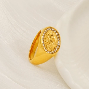 Macro detail of gold floral signet ring featuring embossed pattern and zircon accents