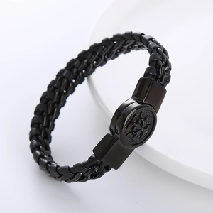 Dettaglio del bracciale in pelle nera intrecciata con chiusura in metallo a croce