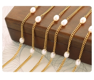 Macro detail of gold-plated flat snake chains and white freshwater pearl necklace joint