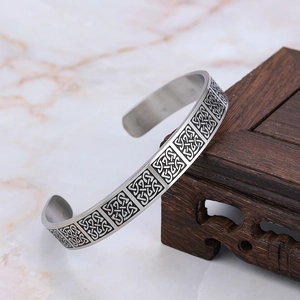 Détail du bracelet manchette Viking vintage argenté avec motifs celtiques sur bois