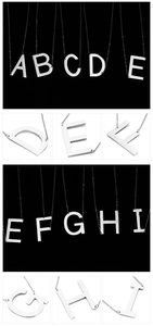 Macro view of silver titanium steel alphabet pendants with polished finish details