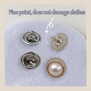 Vintage pearl brooch pins with metal butterfly clutches on a blue felt display