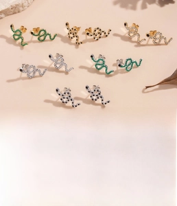 Detailed macro view of snake-shaped titanium earrings with colorful cubic zirconia