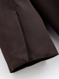 Detaillierte Makroansicht von dunkelbraunem Twill-Gewebe und feiner Naht am Sakko-Ärmel