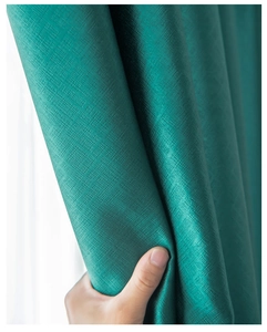 Close-up of green blackout curtain fabric showing high-density texture and drape