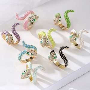 Detail of colorful snake rings with crystal head and evil eye design on white steps