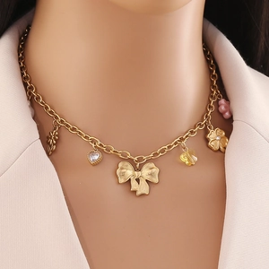Collana in acciaio dorato con fiocco a farfalla, ciondolo a cuore e quadrifoglio
