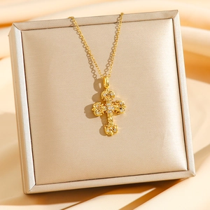 Golden gothic cross pendant necklace with white crystals on a silk and metal background