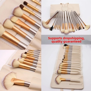 Detail of multi-size makeup brush set with champagne gold handles and storage roll bag