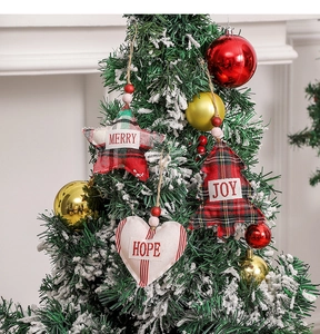 Close-up of fabric Christmas ornaments with Merry, Joy, Hope text hanging on tree
