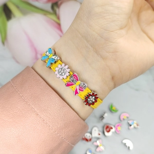 Close-up of colorful alloy charms on a yellow 8mm DIY slide bracelet
