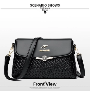 Close-up of black woven leather handbag with golden kangaroo logo and metal flower detail