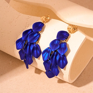 Detail of elegant blue petal tassel earrings with gold posts on a minimalist background