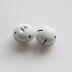 Macro view of white star-shaped cutouts on metal bells for DIY Christmas decor