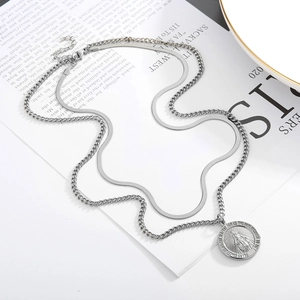 Detail of silver double-layered snake and curb chain necklace with Virgin Mary pendant