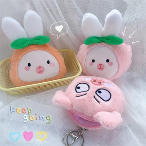 Detailed view of plush pig and carrot coin purses with zippers and keychains
