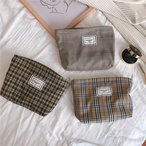 Detailed set of plaid canvas makeup bags in khaki, green and houndstooth patterns