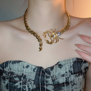 Close-up of a gold-plated scorpion choker necklace with sparkling rhinestones on model
