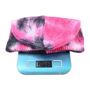 Detailed view of tie-dye knit beanie on an electronic scale weighing 97g for winter