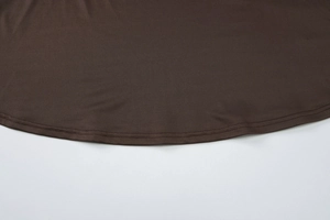 Détail de l'ourlet d'une jupe en maille marron foncé avec couture double de haute qualité
