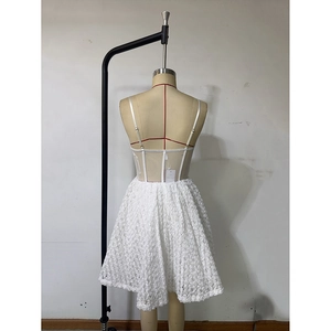 Detail of white corset dress featuring 3D rose textured skirt and back zipper closure