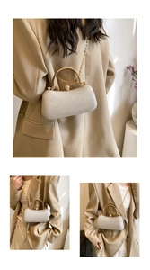Detail of silver glitter evening bag with gold handle and chain on a beige blazer