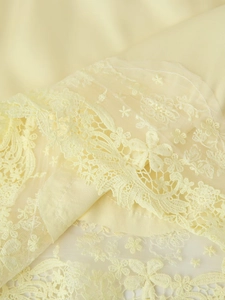 Gros plan sur la broderie en dentelle florale et le satin jaune de haute qualité