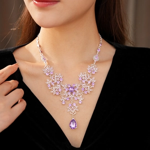 Detail of silver vintage necklace with purple floral stone and teardrop pendant