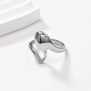 Detailed close-up of a silver irregular fluid-shaped stainless steel ring on a white surface