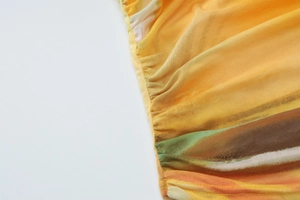 Gros plan sur un tissu en mesh semi-transparent avec imprimé dégradé orange et coutures