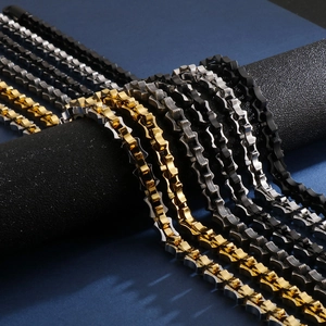 Detail view of gold, silver, and black geometric stainless steel chains in punk style