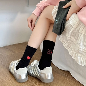 Close-up of crew socks with heart embroidery and Follow your heart text detail