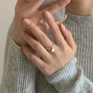 Detail of 925 sterling silver beaded ring with a small round pendant on model hand