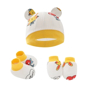Dettaglio di cappello, muffole e scarpine per neonato con stampa coniglietto e ciliegia