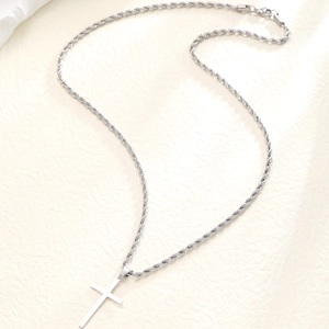 Close-up of a silver stainless steel twist chain necklace with a cross pendant