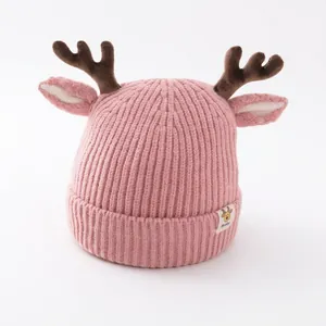 Bonnet bébé rose en tricot avec bois de renne marrons et oreilles pour l'hiver