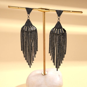 Dark style fan-shaped tassel earrings with zircon inlay on a modern metal display stand
