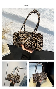 Detailed view of yellow leopard print baguette bag with slim shoulder straps and PU texture