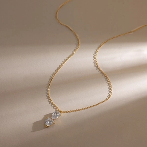 Dettaglio macro della collana in acciaio 18K con doppi pendenti a cuore in zirconia