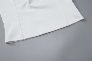 Detailed close-up of white halter top hemline with professional double-stitched edging