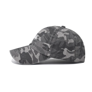 Detailed side view of washed camouflage baseball cap with white artistic embroidery