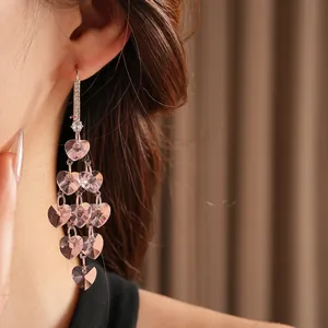Pink heart crystal tassel drop earrings worn by model for elegant fashion styling