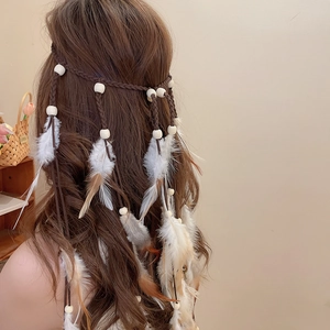Detail eines böhmischen Feder-Stirnbands mit Holzperlen und langen geflochtenen Quasten