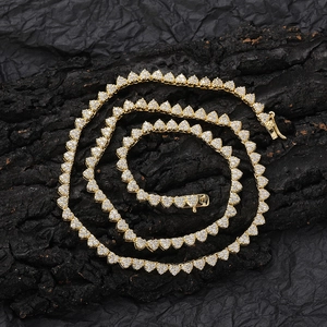 Detailed view of heart-shaped tennis chain with white zircons on a dark textured surface