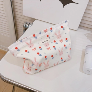 Detail of canvas pouch with cute rabbit print and simple wish label on white desk