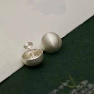 Silver brushed metal sphere clip-on earrings with secure screw-back design for non-pierced ears