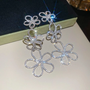 Macro shot of silver flower drop earrings with sparkling rhinestones on jewelry box